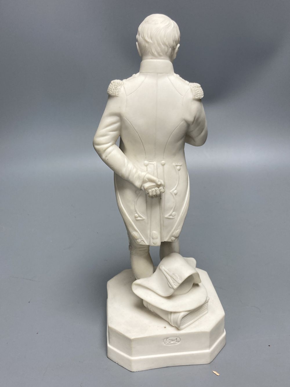 A Robinson & Leadbeater parian figure of Napoleon, standing on shaped square base, 25cm